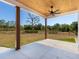 Spacious back porch with wood columns and ceiling fan, perfect for relaxing and enjoying the serene outdoor views at 27510 67Th E Ave, Myakka City, FL 34251