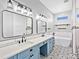 Stylish bathroom featuring double sinks with blue vanity, patterned tile floor, and a modern soaking tub at 27510 67Th E Ave, Myakka City, FL 34251