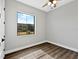 Simple room features wood floors, neutral walls and a window overlooking a green space at 27510 67Th E Ave, Myakka City, FL 34251