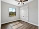 Unfurnished bedroom with hardwood floors, a ceiling fan, and bright window view at 27510 67Th E Ave, Myakka City, FL 34251