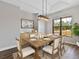 Bright dining room featuring a wooden table, elegant lighting, and a scenic backyard view at 27510 67Th E Ave, Myakka City, FL 34251