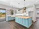 Bright kitchen with a large island, stylish pendant lighting, modern appliances, and open shelves at 27510 67Th E Ave, Myakka City, FL 34251