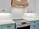 Elegant kitchen featuring stainless steel appliances, custom cabinetry, tile backsplash, and a stylish range hood at 27510 67Th E Ave, Myakka City, FL 34251