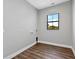 Bright laundry room boasts wood-look flooring and a window with peaceful wooded views at 27510 67Th E Ave, Myakka City, FL 34251