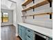 Bright pantry boasts custom shelving, blue cabinets and a beverage center at 27510 67Th E Ave, Myakka City, FL 34251