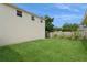 View of the home's expansive backyard with lush green grass and a sturdy privacy fence at 2804 W Mark Dr, Sarasota, FL 34232