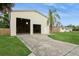 View of the spacious detached garage with two bays, a side door, and a well-manicured lawn at 2804 W Mark Dr, Sarasota, FL 34232