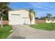 View of the spacious detached garage with two bays, a side door, and a well-manicured lawn at 2804 W Mark Dr, Sarasota, FL 34232