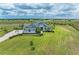 Aerial view of a stunning modern home on a vast landscaped lot with a scenic pond and long driveway at 3518 Recurve Cir, Sarasota, FL 34240