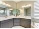 Bright bathroom features dual sinks with granite countertops and cabinetry, with mirrors, lighting, and tiled floors at 3518 Recurve Cir, Sarasota, FL 34240