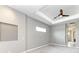 Bright bedroom with a ceiling fan, tray ceiling, a small window, and neutral walls at 3518 Recurve Cir, Sarasota, FL 34240
