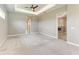 Large bedroom featuring a tray ceiling, ceiling fan, and ample space with neutral walls and carpeted floors at 3518 Recurve Cir, Sarasota, FL 34240