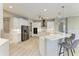 Well-lit kitchen features bar seating, stainless steel appliances, and modern white cabinets at 3518 Recurve Cir, Sarasota, FL 34240
