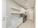 Well-equipped laundry room with sink, quartz counters, cabinets and appliances at 3518 Recurve Cir, Sarasota, FL 34240