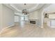 Open-concept living room featuring modern fireplace, light wood floors, and a unique, decorative chandelier at 3518 Recurve Cir, Sarasota, FL 34240