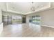 Bright living area with wood-look floors, modern lighting, and views of the outdoor pool and patio at 3518 Recurve Cir, Sarasota, FL 34240