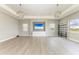 Elegant living room with wood-look floors, built-in media center, and modern light fixtures at 3518 Recurve Cir, Sarasota, FL 34240