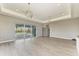 Spacious living room with sliding glass doors leading to the pool area and sleek wood-look flooring at 3518 Recurve Cir, Sarasota, FL 34240