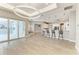 Open living area with tile floors, modern lighting, and a partial view of the kitchen and outdoor patio at 3518 Recurve Cir, Sarasota, FL 34240