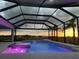 Stunning twilight view of screened pool with a spa and water feature, offering a luxurious outdoor retreat at 3518 Recurve Cir, Sarasota, FL 34240