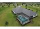 Aerial view of a private screened-in pool with a jacuzzi, surrounded by a well-manicured lawn at 3518 Recurve Cir, Sarasota, FL 34240