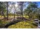 Lush backyard with mature trees, offering a serene view and plenty of natural shade at 3521 Fair Oaks Ln, Longboat Key, FL 34228