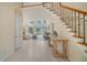 Bright foyer features a staircase with wood railing and entry to the living room with floor-to-ceiling windows at 3521 Fair Oaks Ln, Longboat Key, FL 34228
