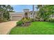 Charming front exterior with lush landscaping and well-manicured lawn at 3521 Fair Oaks Ln, Longboat Key, FL 34228