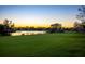 Golf course view featuring sunset and pond at 3521 Fair Oaks Ln, Longboat Key, FL 34228