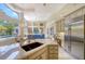 Open kitchen featuring marble countertops, stainless appliances, and a large refrigerator at 3521 Fair Oaks Ln, Longboat Key, FL 34228
