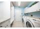 Laundry room with white cabinets, granite countertops, and front-loading washer and dryer at 3521 Fair Oaks Ln, Longboat Key, FL 34228