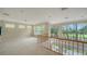 Bright loft area with neutral carpet, three large windows, and a railing overlooking the entry at 3521 Fair Oaks Ln, Longboat Key, FL 34228