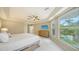 Spacious main bedroom with a tray ceiling, fan, dresser, and view of the pool, ideal for relaxation and rest at 3521 Fair Oaks Ln, Longboat Key, FL 34228