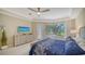 Bright main bedroom with a large window offering picturesque views of the lush greenery and a decorative ceiling fan at 3521 Fair Oaks Ln, Longboat Key, FL 34228