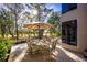 Charming outdoor patio featuring a dining set and umbrella, ideal for entertaining and enjoying the scenic views at 3521 Fair Oaks Ln, Longboat Key, FL 34228