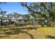 View of property featuring mature trees, a chain link fence, and the side of the home at 3619 Elm St, Ellenton, FL 34222