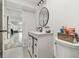 Modern bathroom with white vanity, stylish round mirror, and sliding barn door at 3619 Elm St, Ellenton, FL 34222