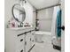 Well-lit bathroom with a white vanity, round mirror, and a shower-tub combo with grey tile at 3619 Elm St, Ellenton, FL 34222