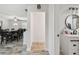 Hallway view with the bathroom, featuring a modern vanity and round mirror at 3619 Elm St, Ellenton, FL 34222
