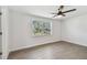 Bright bedroom featuring hardwood floors, a ceiling fan, and a large window with natural light at 3619 Elm St, Ellenton, FL 34222
