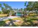 Charming single-story home with a covered, screened-in parking area and mature landscaping at 3619 Elm St, Ellenton, FL 34222