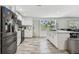 Bright kitchen with white cabinets, wood-look tile flooring, and stainless steel appliances at 3619 Elm St, Ellenton, FL 34222