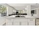 Kitchen island with white cabinets and sink, bright open space to the living room at 3619 Elm St, Ellenton, FL 34222