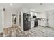 Bright kitchen with white cabinets, wood-look tile flooring, and stainless steel appliances at 3619 Elm St, Ellenton, FL 34222