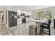 Well-lit kitchen with stainless steel appliances, white cabinets and an island with breakfast bar at 3619 Elm St, Ellenton, FL 34222