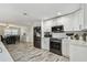 Bright kitchen with white cabinets, wood-look tile flooring, and stainless steel appliances at 3619 Elm St, Ellenton, FL 34222