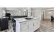 Bright kitchen island featuring a sink and white cabinets, open to the living area at 3619 Elm St, Ellenton, FL 34222