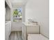 Laundry room with white cabinets and appliances, natural light and wood-look tile flooring at 3619 Elm St, Ellenton, FL 34222