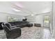 Bright living room with a comfortable sectional sofa, exercise bike, and wood-look tile flooring at 3619 Elm St, Ellenton, FL 34222