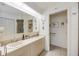 Bright bathroom featuring dual sinks, a large mirror, and a doorway to the toilet at 3662 Bonaventure Ct, Sarasota, FL 34243